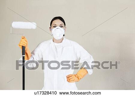 Portrait of a female worker in protective workwear holding paint roller with hand on hip View Large Photo Image Stock Image - Portrait of a female worker in protective workwear holding paint roller with hand on hip. Fotosearch