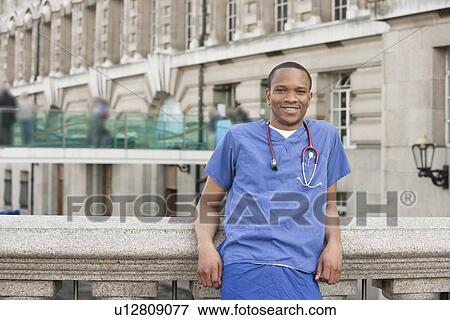 Portrait of an African American male doctor smiling with building in background View Large Photo Image Stock Photo - Portrait of an African American male doctor smiling with building in background. Fotosearch