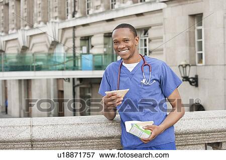 Stock Photo - Portrait of an African American male surgeon having a sandwich. Fotosearch