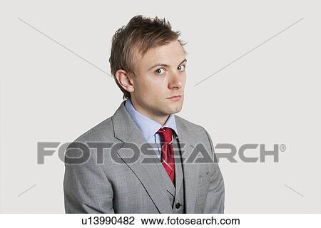 Portrait of angry young businessman over light gray background View Large Photo Image Stock Image - Portrait of angry young businessman over light gray background. Fotosearch