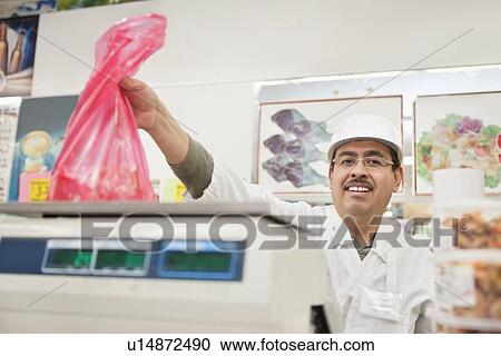 Portrait of butcher giving away meat in plastic bag View Large Photo Image Stock Image - Portrait of butcher giving away meat in plastic bag. Fotosearch