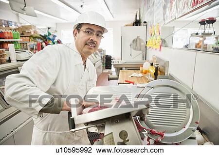 Portrait of butcher putting steak in fly wheel slicer View Large Photo Image Stock Image - Portrait of butcher putting steak in fly wheel slicer. Fotosearch