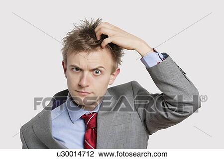 Portrait of confused businessman scratching head over colored background View Large Photo Image Stock Image - Portrait of confused businessman scratching head over colored background. Fotosearch