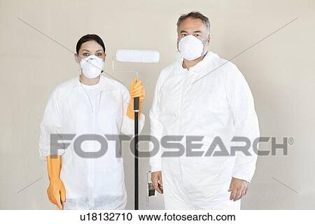 Portrait of female worker holding paint roller with man standing with her View Large Photo Image Stock Image - Portrait of female worker holding paint roller with man standing with her. Fotosearch