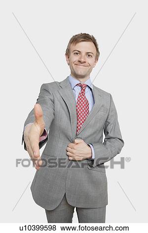 Stock Photo - Portrait of handsome young businessman extending hand for a handshake. Fotosearch