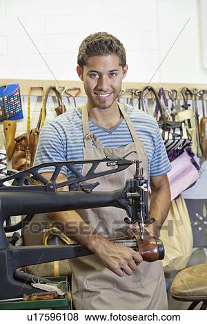 Portrait of handsome young shoemaker working on machinery View Large Photo Image Stock Photo - Portrait of handsome young shoemaker working on machinery. Fotosearch