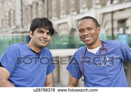 Portrait of multi ethnic doctors smiling with building in background View Large Photo Image Stock Photo - Portrait of multi ethnic doctors smiling with building in background. Fotosearch