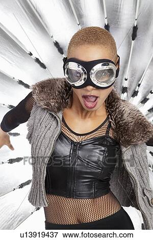 Stock Photo - Portrait of young African American woman wearing pilot goggles with open mouth. Fotosearch