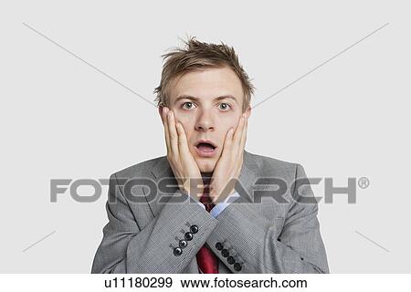 Portrait of young businessman in shock over colored background View Large Photo Image Stock Photo - Portrait of young businessman in shock over colored background. Fotosearch