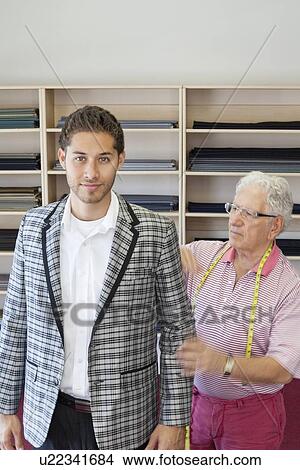 Picture - Portrait of young man having custom made suit in tailor's shop. Fotosearch