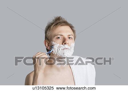 Portrait of young man saving with towel on shoulder over colored background View Large Photo Image Stock Photography - Portrait of young man saving with towel on shoulder over colored background. Fotosearch