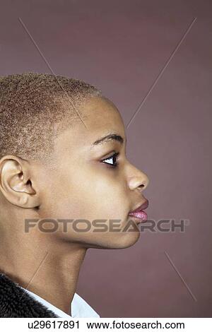 Stock Image - Profile view of shaved African American woman over colored background. Fotosearch