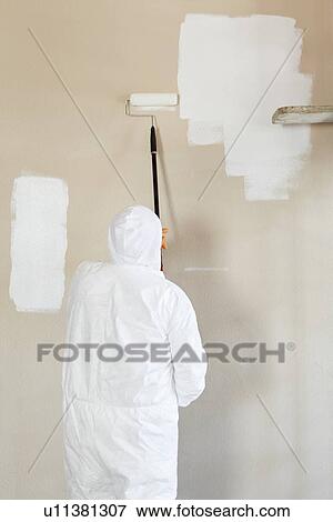 Rear view of male worker in protective workwear painting wall View Large Photo Image Stock Photo - Rear view of male worker in protective workwear painting wall. Fotosearch