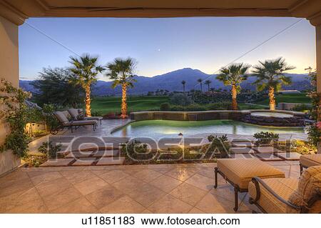 Stock Image - Seating furniture in patio at dusk. Fotosearch