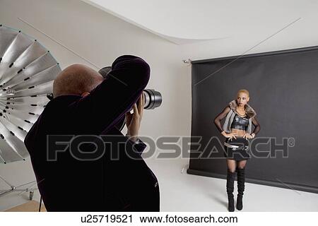 Senior photographer shooting a fashion model in studio View Large Photo Image Stock Image - Senior photographer shooting a fashion model in studio. Fotosearch