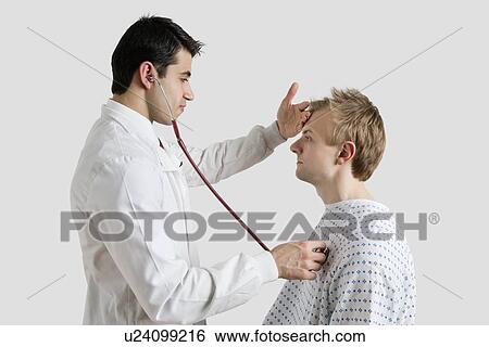 Side view of doctor examining male patient with stethoscope View Large Photo Image Stock Photograph - Side view of doctor examining male patient with stethoscope. Fotosearch