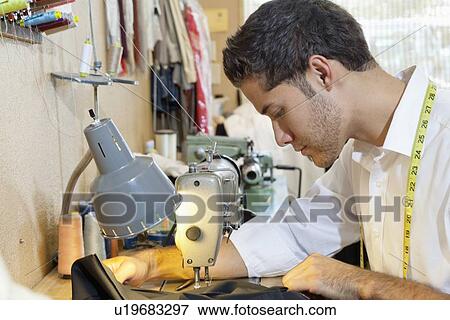 Side view of young man tailoring cloth in shop View Large Photo Image Stock Photo - Side view of young man tailoring cloth in shop. Fotosearch