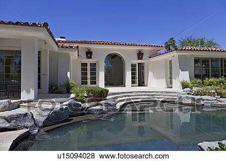 Stock Photo - Swimming pool in front of luxury villa. Fotosearch