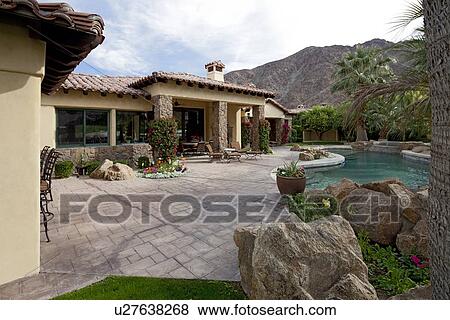 Stock Photo - Swimming pool in luxurious mansion with mountain in background. Fotosearch