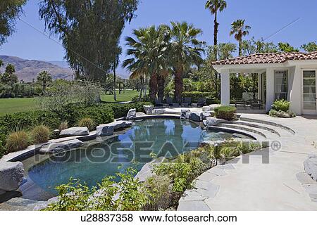 Stock Photo - Swimming pool of luxury villa with mountain in background. Fotosearch