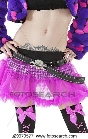 Stock Photo - Torso of a tattooed woman wearing a skull and crossbones belt. Fotosearch