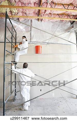 Stock Photo - Two construction workers painting a room. Fotosearch
