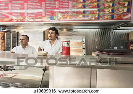 Two mid adult men working in fast food shop View Large Photo Image Stock Photograph - Two mid adult men working in fast food shop. Fotosearch