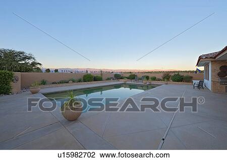 Stock Image - View of landscape with swimming pool in foreground. Fotosearch