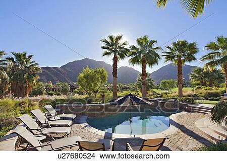 Picture - View of mountains from sun loungers near swimming pool in manor house. Fotosearch
