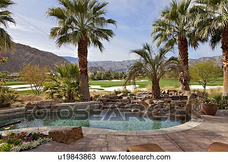 Stock Image - View of swimming pool with private golf course in background. Fotosearch