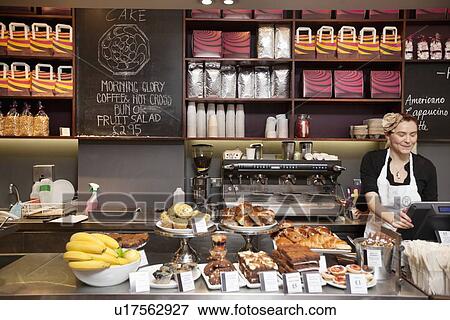Young adult woman working in bakery shop View Large Photo Image Stock Photo - Young adult woman working in bakery shop. Fotosearch