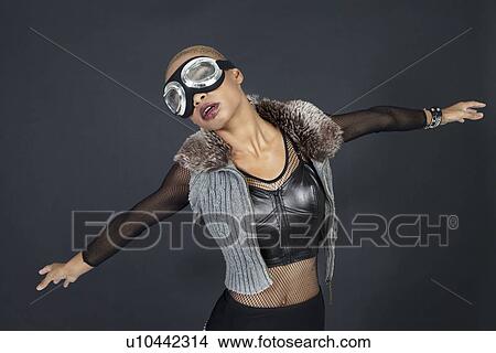 Young African American woman pretending as aircraft over colored background View Large Photo Image Picture - Young African American woman pretending as aircraft over colored background. Fotosearch