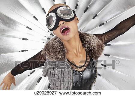 Stock Photo - Young African American woman with pilot goggles over reflector umbrella. Fotosearch