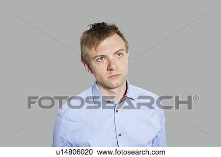 Young man in pensive mood over colored background View Large Photo Image Stock Image - Young man in pensive mood over colored background. Fotosearch