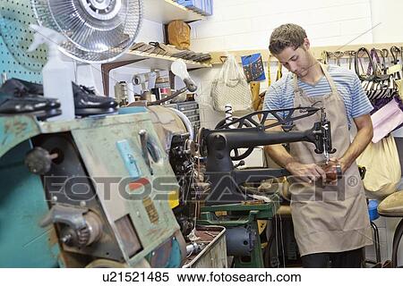 Stock Photography - Young shoemaker concentrating on work. Fotosearch