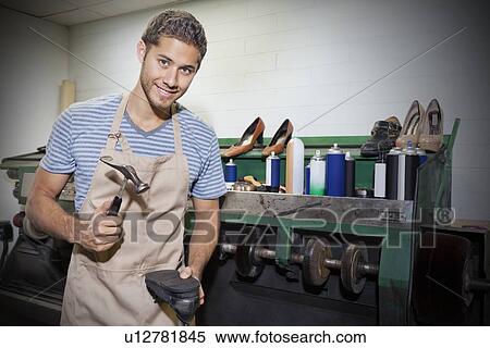 Young shoemaker hammering shoe sole in workshop View Large Photo Image Stock Photography - Young shoemaker hammering shoe sole in workshop. Fotosearch
