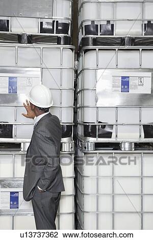 Stock Image - African American male engineer inspecting in manufacturing company. Fotosearch
