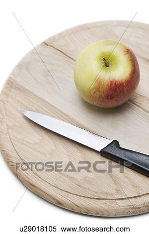 Stock Photography - Apple and knife on wooden plate over white background. Fotosearch