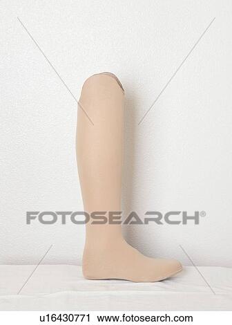 Stock Image - Artificial leg over gray wall. Fotosearch