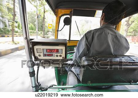 Stock Photo - Back view of an auto rickshaw driver on the street, New Delhi, India. Fotosearch