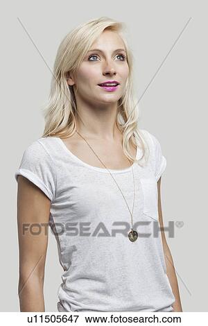 Beautiful young woman in white tshirt with pink lips looking up over gray background View Large Photo Image Stock Photo - Beautiful young woman in white tshirt with pink lips looking up over gray background. Fotosearch
