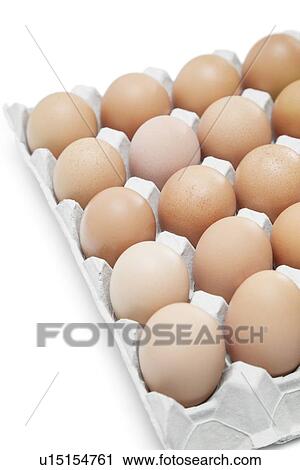 Stock Image - Brown eggs arranged in carton over white background. Fotosearch