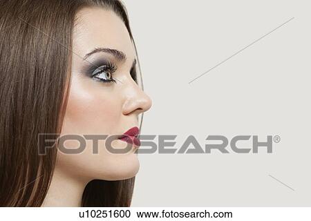 Close-up of a beautiful young woman over gray background View Large Photo Image Stock Image - Close-up of a beautiful young woman over gray background. Fotosearch