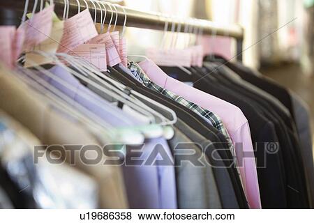 Stock Photo - Close-up of shirts on hangers in store. Fotosearch