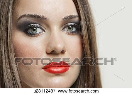 Close-up portrait of a beautiful young woman over gray background View Large Photo Image Stock Photo - Close-up portrait of a beautiful young woman over gray background. Fotosearch