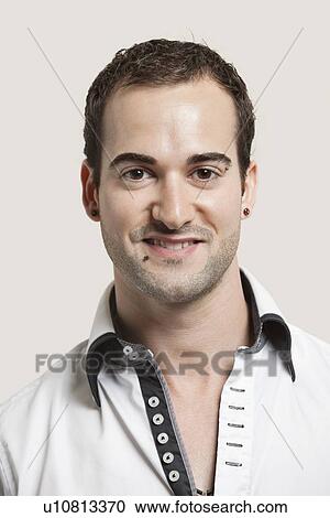 Close-up portrait of young man smiling over gray background View Large Photo Image Stock Image - Close-up portrait of young man smiling over gray background. Fotosearch