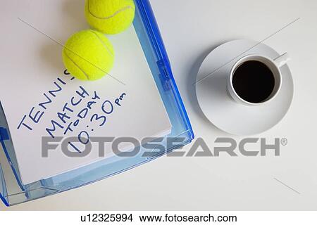 Picture - Coffee cup with tennis balls and note on surface. Fotosearch