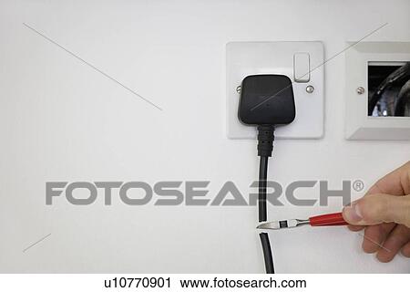 Cropped shot of hand cutting electrical cord attached to outlet on white wall View Large Photo Image Stock Image - Cropped shot of hand cutting electrical cord attached to outlet on white wall. Fotosearch
