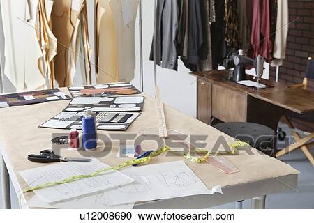 Stock Image - Fashion designing materials on table in design studio. Fotosearch