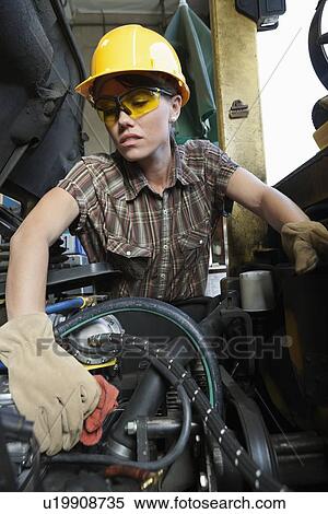 Female industrial worker cleaning vehicle part View Large Photo Image Stock Photography - Female industrial worker cleaning vehicle part. Fotosearch
